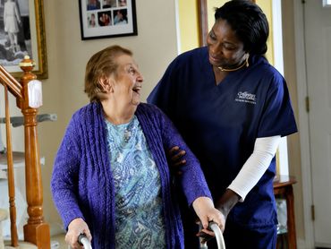 Nurse walking with elderly woman.