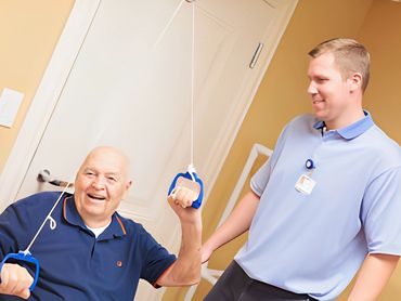 Physical therapist training senior man.