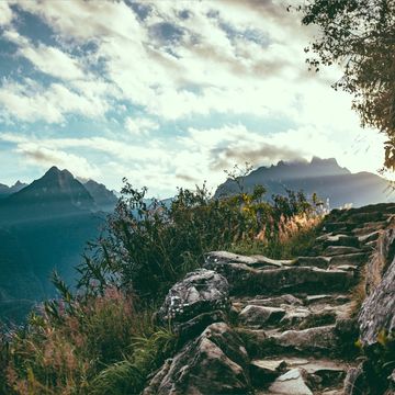 Rocky mountain trail with sunlight in the distance