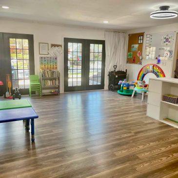 Bright and spacious children's playroom with toys and learning materials.
