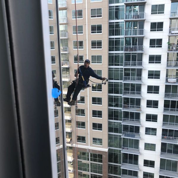 Professional high-rise window cleaning downtown Atlanta using rope access safety system.