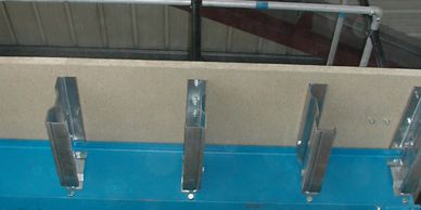 Cantilevered stub beams with 38mm particle board decking bolted to main steel of a mezzanine floor 