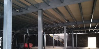 Galvanised steel column casings fitted to the columns of a decked mezzanine floor at a Kent site.