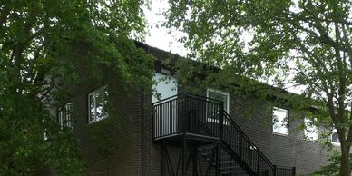 An external fire escape staircase fitted with childsafe vertical bar handrail at a Kent school.