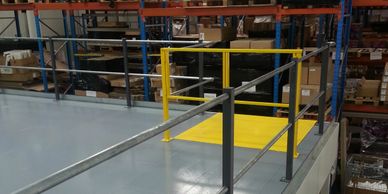 Double tubular mezzanine floor handrail with recessed pallet loading area and biparting safety gate.