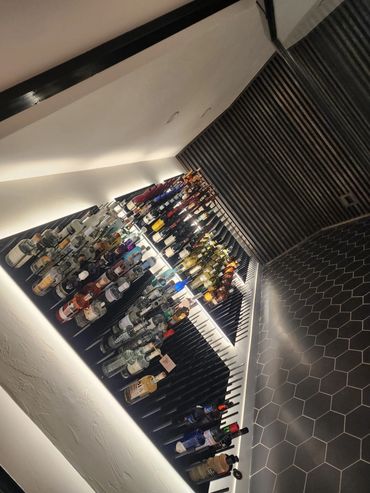 A wine cellar with many bottles of alcohol on the shelves.