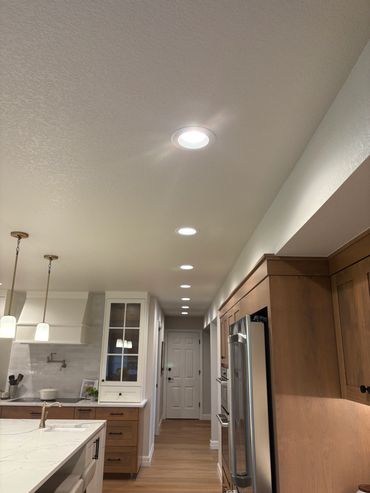 A kitchen with white walls and wooden cabinets.