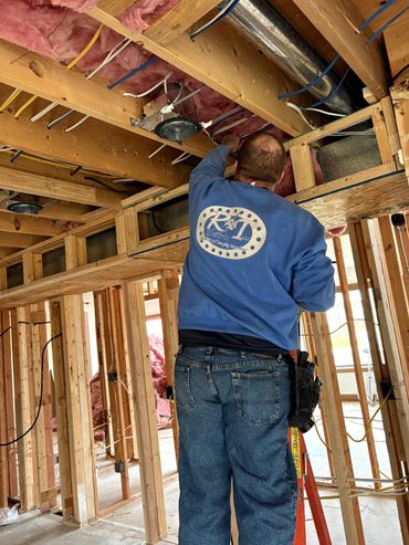 A man in blue shirt working on ceiling.