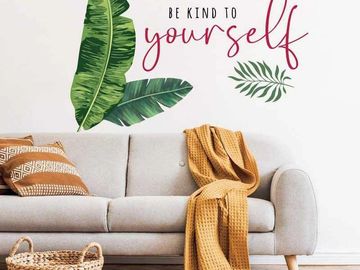 Cozy living room with a gray sofa, mustard throw, and leafy wall art.