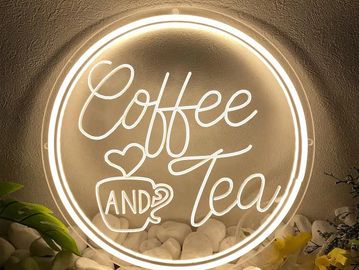 Illuminated sign reading 'Coffee and Tea' with heart-shaped steam above a cup.