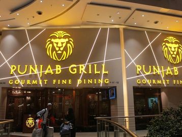 Entrance of Punjab Grill gourmet fine dining restaurant with illuminated lion logo.