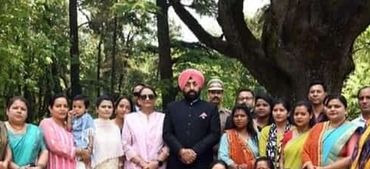 A large group of men, women, and children gathered outdoors for a group photo.