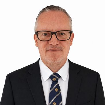 Portrait of a man in a suit and glasses.