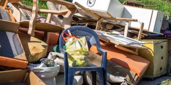 A pile of discarded furniture and household items outdoors.