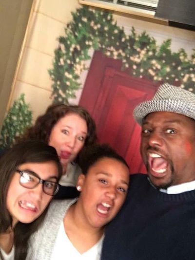 Angie and her husband Donnie stand behind their two preteen daughters, making silly faces.