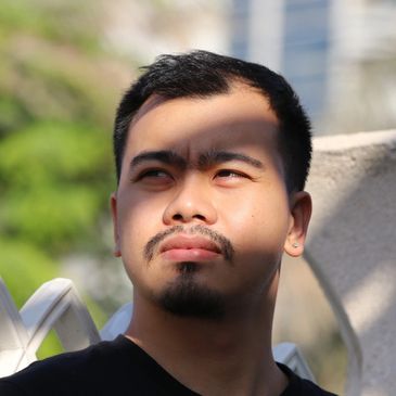 Man with a contemplative expression and shadowed face in sunlight.