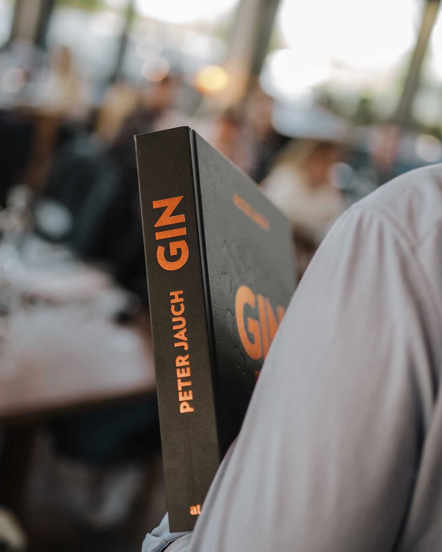 Peter Jauch hält Gin Das Buch mit dem Buchrücken in die Kamera.