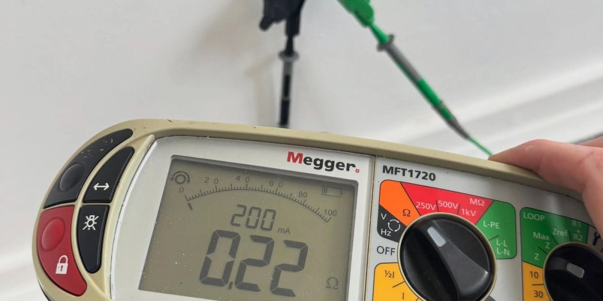 Close-up of a Megger MFT1720 electrical tester displaying 0.22 ohms.