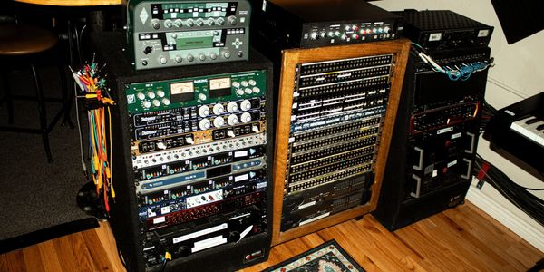 Professional audio equipment racks with various sound processing units.