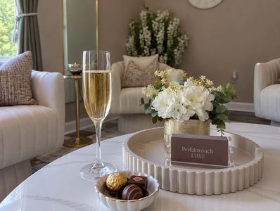Elegant living room setup with champagne and chocolates.