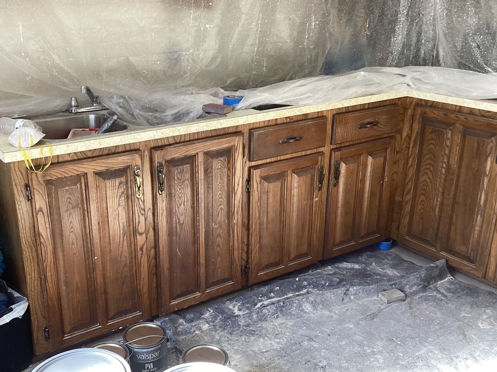 Before kitchen cabinet painting in Houma LA – dark stained cabinets with old exposed hinges