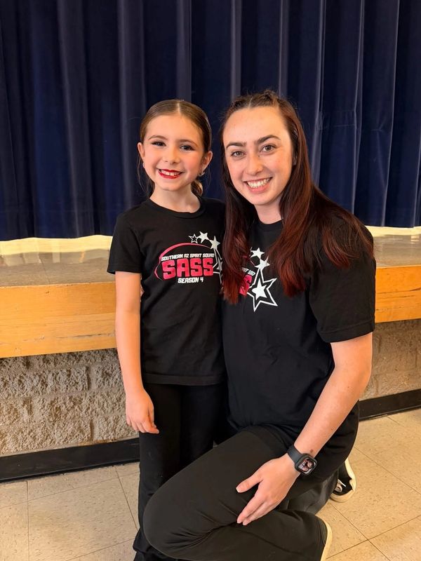 Young girl and woman smiling in matching SASS shirts.