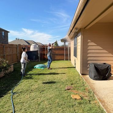 Worker cutting concrete with a power tool, creating dust.