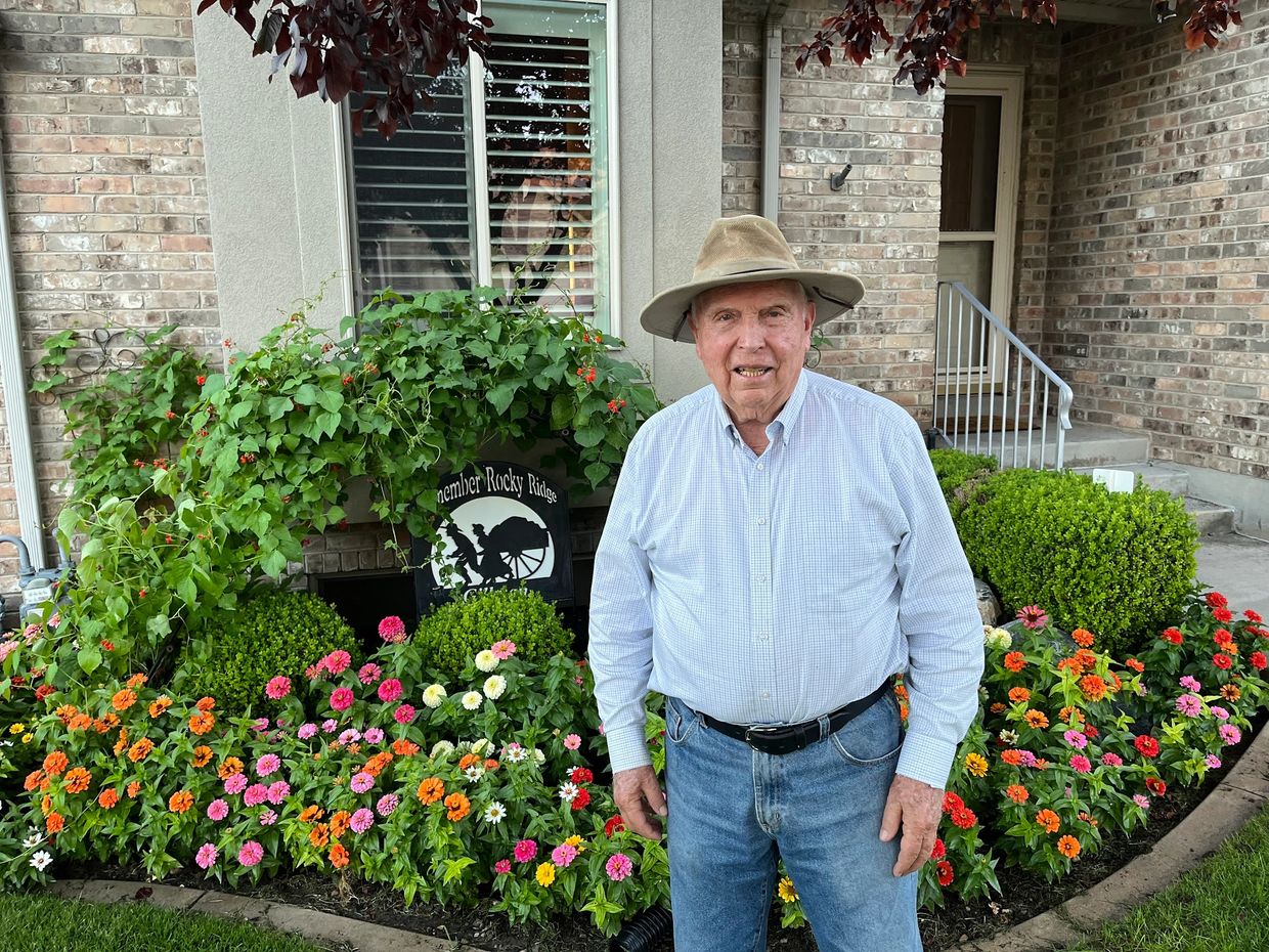 LaDell Gillman stands in front of his flower beds.