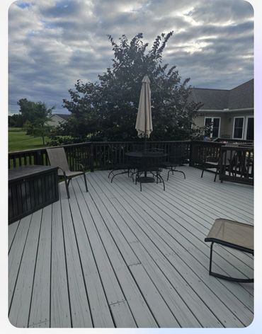 Spacious backyard deck with outdoor furniture and a cloudy sky.