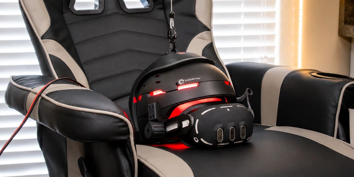 A futuristic VR headset with red lights resting on a black and gray gaming chair.