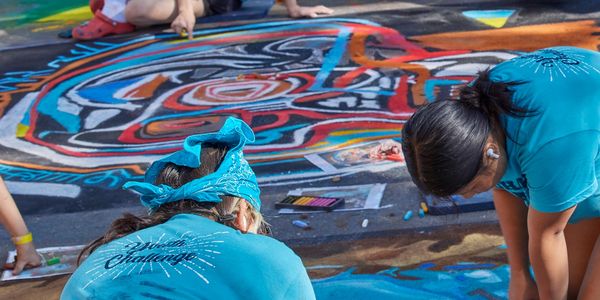 Young artists drawing together at the 2022 Denver chalk art festival