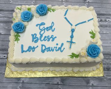 Half sheet cake for communion with blue roses and cross. Frosted in butter cream