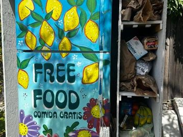 Colorful free food fridge with lemons and flowers.