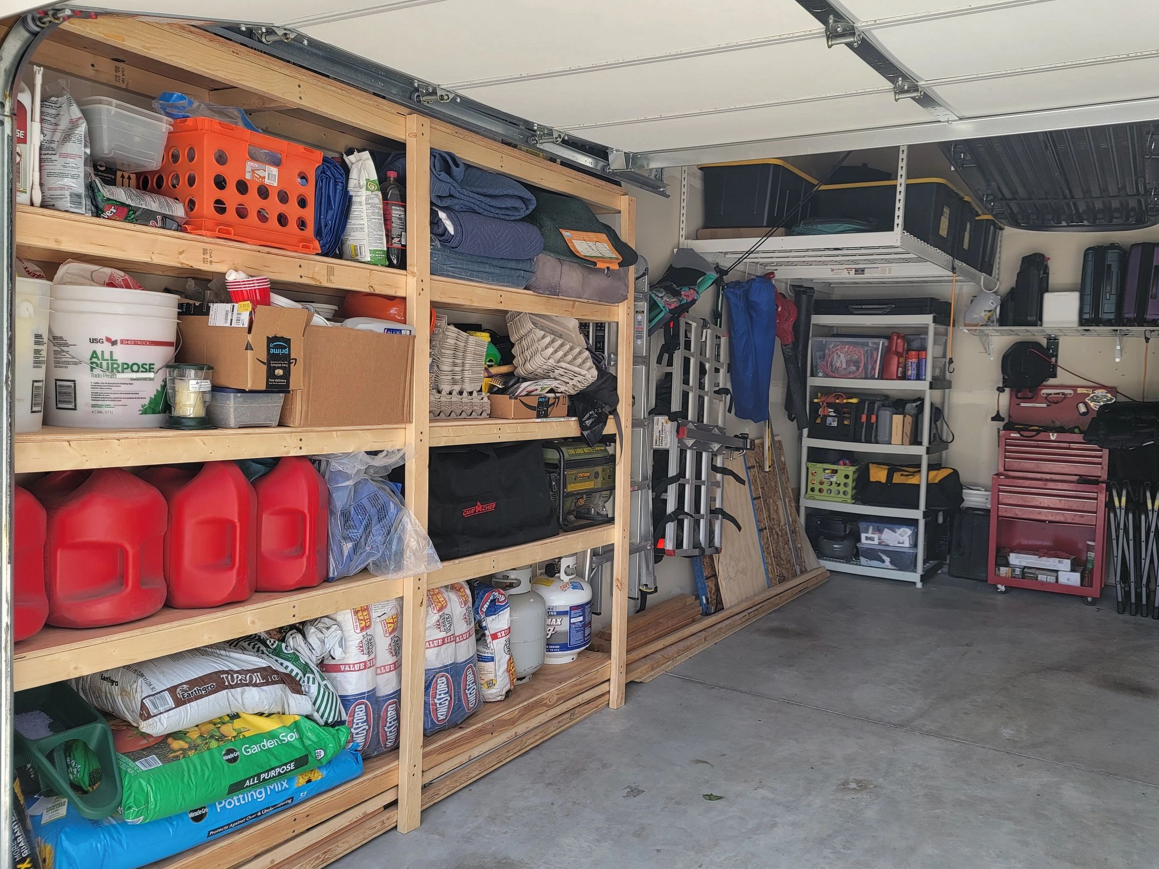 maximized garage space with wall shelves, ceiling racks, roof cargo pulley, tool box & deep freezer