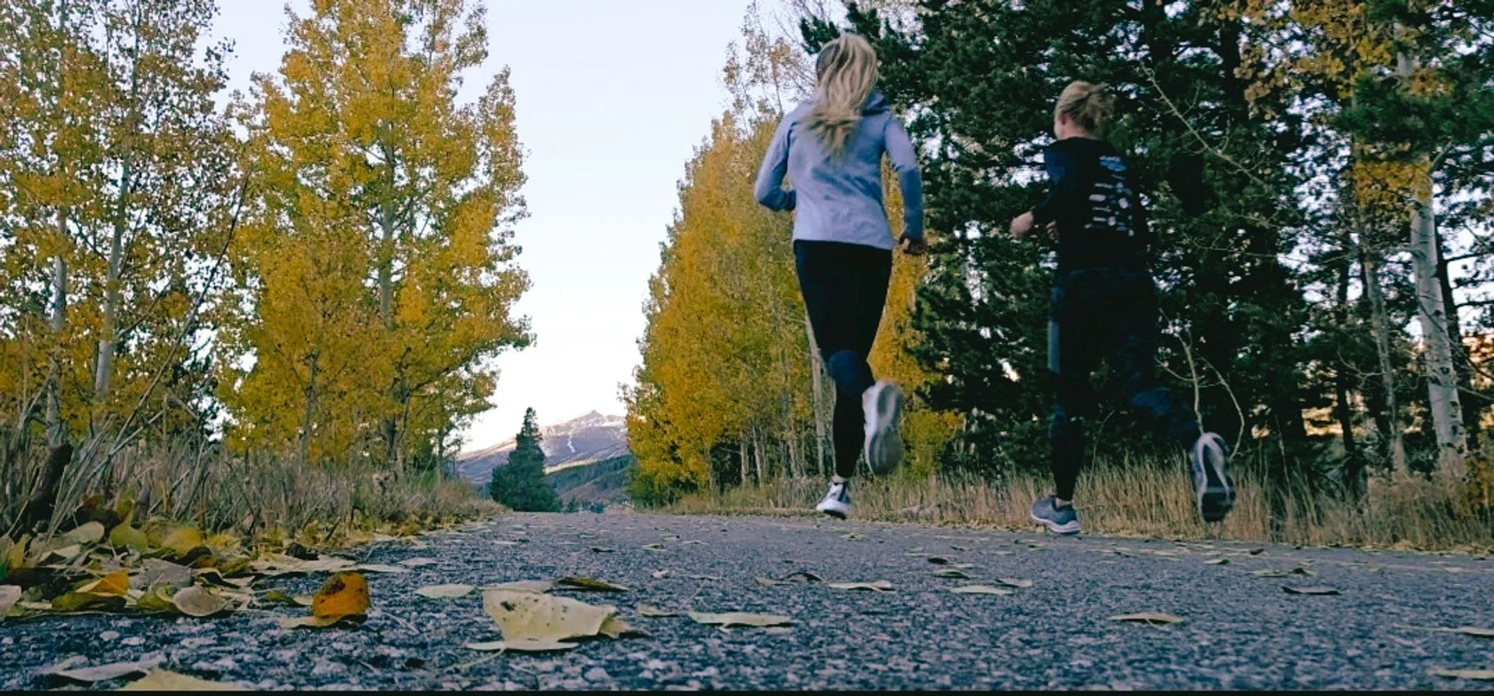 Run coach with athlete running in mountains