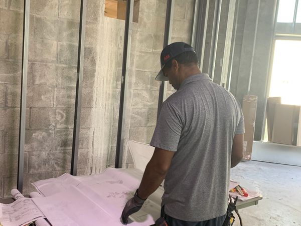 Man in a cap reviewing blueprints in a construction site.