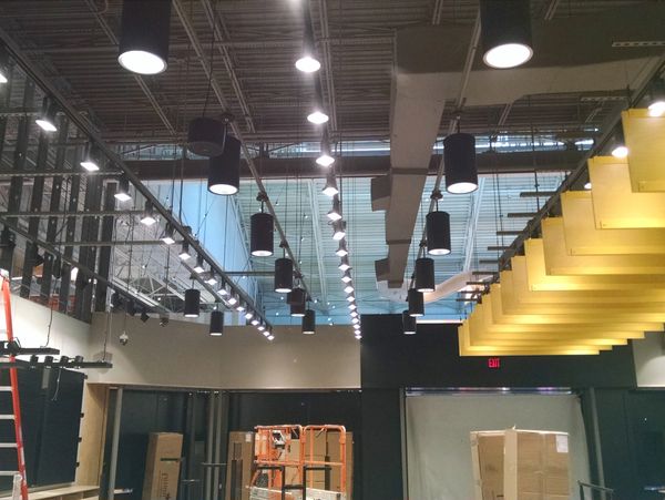 Interior of a modern commercial space under construction with lighting and ceiling fixtures.