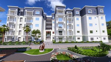 Modern apartment building with landscaped garden under clear blue sky.