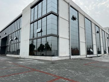 Modern commercial building with large glass windows and an open courtyard.