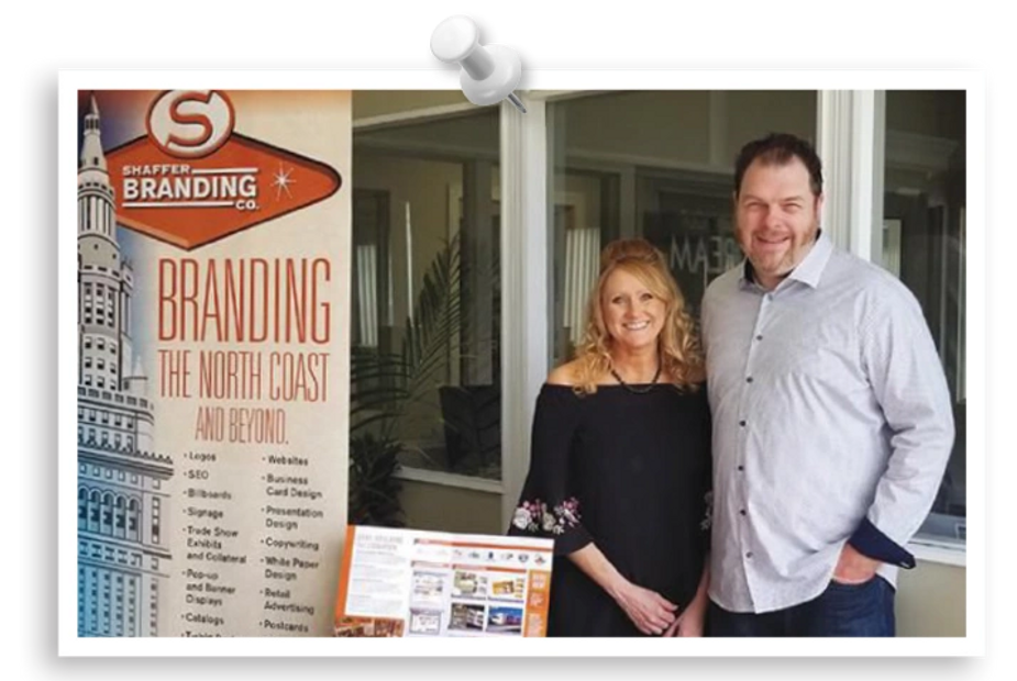 Founding Partners Stacey and Rick Shaffer in front of Trade Show banner with the SBC logo.