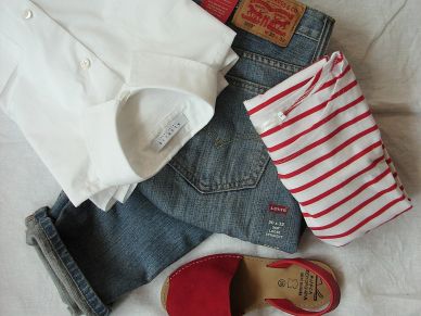 Casual outfit with white shirt, striped top, denim jeans, and red shoes.