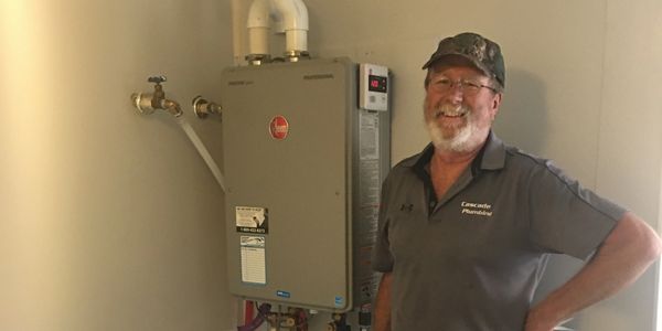 plumber standing next to a new tankless water heater