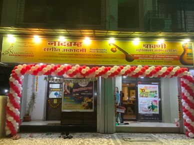 Music academy decorated with red and white balloons for an anniversary celebration.