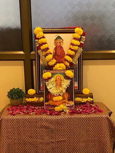 A decorated altar with framed portraits, garlands, and offerings.