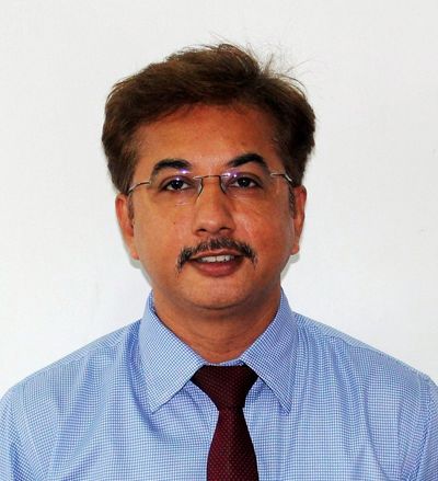 Man in glasses with mustache wearing blue shirt and maroon tie.