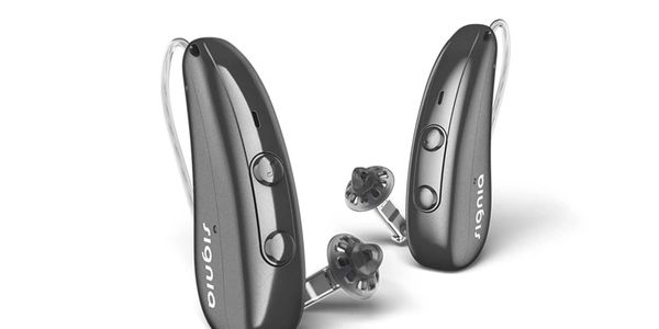 A pair of black Signia hearing aids with control buttons and earpieces.
