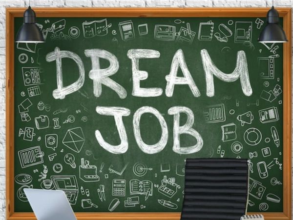Chalkboard with 'DREAM JOB' and office items, laptop, and chair.
