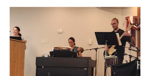 Three musicians performing indoors with various instruments.