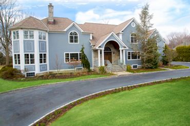 Large gray and white house with stone entry.