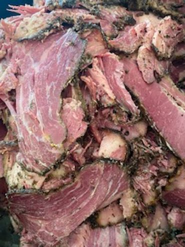 Slices of rich, slow-smoked pastrami layered beautifully, showing a perfect smoke ring.
